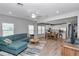 Open-concept living room features a comfortable blue sectional sofa and seamless access to the modern kitchen area at 9262 Sw 58Th Cir, Ocala, FL 34476