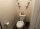 Cozy half bathroom featuring a decorative toilet seat and ornate candle sconces at 1185 Sabine Ln, Kissimmee, FL 34759