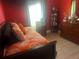 Bright bedroom with an orange and white comforter, hardwood floors and matching wooden furniture at 1185 Sabine Ln, Kissimmee, FL 34759