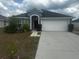 Inviting single-story home featuring a well-manicured lawn and a convenient two-car garage at 1185 Sabine Ln, Kissimmee, FL 34759