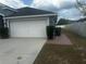 A view of the two-car garage with an attached driveway at 1185 Sabine Ln, Kissimmee, FL 34759