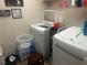 Bright laundry room featuring a white washer, dryer, and ample storage space at 1185 Sabine Ln, Kissimmee, FL 34759