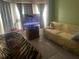 Living room with a yellow print couch, tiger print ottoman and a flat screen TV at 1185 Sabine Ln, Kissimmee, FL 34759