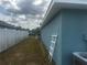 Side yard with a white picket fence, blue house and ladder at 1185 Sabine Ln, Kissimmee, FL 34759