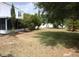 Backyard features mature trees, a well-manicured lawn, and the exterior of the house at 1009 Ronlin St, Haines City, FL 33844