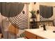 Bathroom features a single sink vanity, patterned shower curtain, and decor at 1009 Ronlin St, Haines City, FL 33844