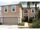 Two-story home with attached two-car garage, neutral stucco siding, decorative trim, and covered front entry at 1009 Ronlin St, Haines City, FL 33844