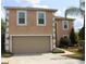 Two-story home featuring an attached two-car garage, neutral stucco siding, and decorative white trim at 1009 Ronlin St, Haines City, FL 33844