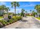 Community entrance sign landscaped with flowers and palm trees at 10160 Mallard Landings Way, Orlando, FL 32832