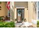 Inviting front door and covered porch with American flag, stylish lantern, and inviting welcome mat at 10160 Mallard Landings Way, Orlando, FL 32832