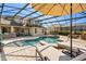 Backyard with a screened-in pool and spa, outdoor kitchen, and lounge chairs at 10160 Mallard Landings Way, Orlando, FL 32832