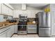 An updated kitchen with butcher block countertops, mosaic tile backsplash, stainless steel appliances, and white cabinets at 1017 Love Ln # 34, Apopka, FL 32703