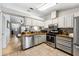 Well-lit kitchen with stainless steel appliances, light gray cabinets, and view to open concept living room at 1017 Love Ln # 34, Apopka, FL 32703