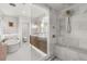 Bright bathroom featuring marble walls, glass enclosed shower, soaking tub and double sink vanity at 104 Cortland Ave, Winter Park, FL 32789