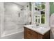 A modern bathroom features marble shower, new fixtures, a vanity, and a window allowing natural light at 104 Cortland Ave, Winter Park, FL 32789