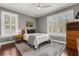 Cozy bedroom with hardwood floors, neutral colors, ceiling fan, and two large windows at 104 Cortland Ave, Winter Park, FL 32789