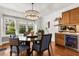 Bright dining room with modern light fixture, dark wood table and beverage center with wine cooler at 104 Cortland Ave, Winter Park, FL 32789