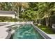 A swimming pool surrounded by lush landscaping, complemented by lounge chairs, creates a private outdoor retreat at 104 Cortland Ave, Winter Park, FL 32789