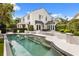 Back of house featuring the pool, with tile trim, integrated steps, and a spacious patio, perfect for outdoor relaxation at 104 Cortland Ave, Winter Park, FL 32789