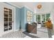 Bright sunroom with blue accent wall, patterned tile floor, and stylish furnishings at 104 Cortland Ave, Winter Park, FL 32789