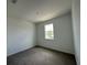 Bright bedroom features a window that provides natural light and neutral-toned walls and carpet at 1141 Lakeshore Breeze Pl, Kissimmee, FL 34747