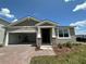 Charming single-Gathering home with a brick driveway, a two-car garage, and a covered entrance at 1141 Lakeshore Breeze Pl, Kissimmee, FL 34747