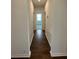 Hallway with wood floors leading to a bedroom with natural light streaming through the window at 1141 Lakeshore Breeze Pl, Kissimmee, FL 34747