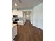 Modern kitchen featuring stainless steel appliances, and a seamless transition into a hallway with wood flooring at 1141 Lakeshore Breeze Pl, Kissimmee, FL 34747