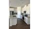 Modern kitchen with white cabinets, granite countertops, stainless steel appliances, and hardwood floors at 1141 Lakeshore Breeze Pl, Kissimmee, FL 34747