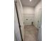 Functional laundry room with tiled floor, white walls, wire rack shelf, and washer/dryer hookups at 1141 Lakeshore Breeze Pl, Kissimmee, FL 34747