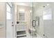 Bright bathroom featuring a modern vanity and glass-enclosed shower with tiled walls and marble floors at 1190 Pecan St, Kissimmee, FL 34744