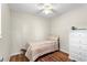 Comfortable bedroom with a ceiling fan, wooden floors, and a triple dresser with a decorative flower at 1190 Pecan St, Kissimmee, FL 34744