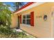 A charming front entrance with red shutters, a wreath, and a modern lighting fixture at 1190 Pecan St, Kissimmee, FL 34744