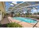 Backyard pool surrounded by a screened-in patio, landscaping, and an outdoor seating area at 1190 Pecan St, Kissimmee, FL 34744