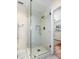 A newly remodeled glass shower with marble-style tile and a modern shower head and handle at 1190 Pecan St, Kissimmee, FL 34744