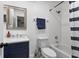 Well-lit bathroom with a shower-tub combo, navy vanity, and a framed mirror at 12661 Somerset Oaks St, Orlando, FL 32828