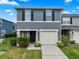 Two-story home featuring manicured landscaping, a one-car garage, and modern black accents at 12661 Somerset Oaks St, Orlando, FL 32828