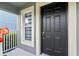 Inviting entrance with black front door, green bushes, and a bright window at 12661 Somerset Oaks St, Orlando, FL 32828