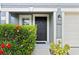 Close-up of front door featuring dark accents, blooming bushes and lush green foliage at 12661 Somerset Oaks St, Orlando, FL 32828