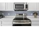 Close up of stainless steel oven and microwave appliances with white cabinetry at 12661 Somerset Oaks St, Orlando, FL 32828