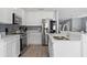 The kitchen features stainless steel appliances, white cabinets, and hardwood floors at 12661 Somerset Oaks St, Orlando, FL 32828