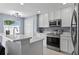 Well-lit kitchen features white cabinetry, stainless steel appliances, and hardwood floors at 12661 Somerset Oaks St, Orlando, FL 32828
