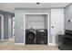 Laundry room featuring a modern washer and dryer, closet and wooden floors at 12661 Somerset Oaks St, Orlando, FL 32828