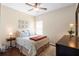 Comfortable bedroom features a ceiling fan, wood floor, and a cozy bed with floral-patterned bedding at 1286 Tallow Rd, Apopka, FL 32703