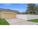 Home featuring a two-car garage, spacious driveway, white fence, and manicured lawn at 1286 Tallow Rd, Apopka, FL 32703