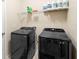 Functional laundry room featuring modern black washer and dryer with storage shelves and overhead lighting at 1286 Tallow Rd, Apopka, FL 32703