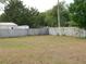 Fenced backyard with a mix of dead and green grass, bordered by trees and other vegetation at 130 Krider Rd, Sanford, FL 32773