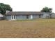 View of the back of the house with a large backyard mostly consisting of dead grass at 130 Krider Rd, Sanford, FL 32773