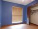 Blue bedroom with hardwood floors, a window with blinds, and a closet with bi-fold doors at 130 Krider Rd, Sanford, FL 32773