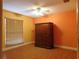 Bedroom featuring light wood flooring, orange and yellow walls, with a ceiling fan and large wooden wardrobe at 130 Krider Rd, Sanford, FL 32773